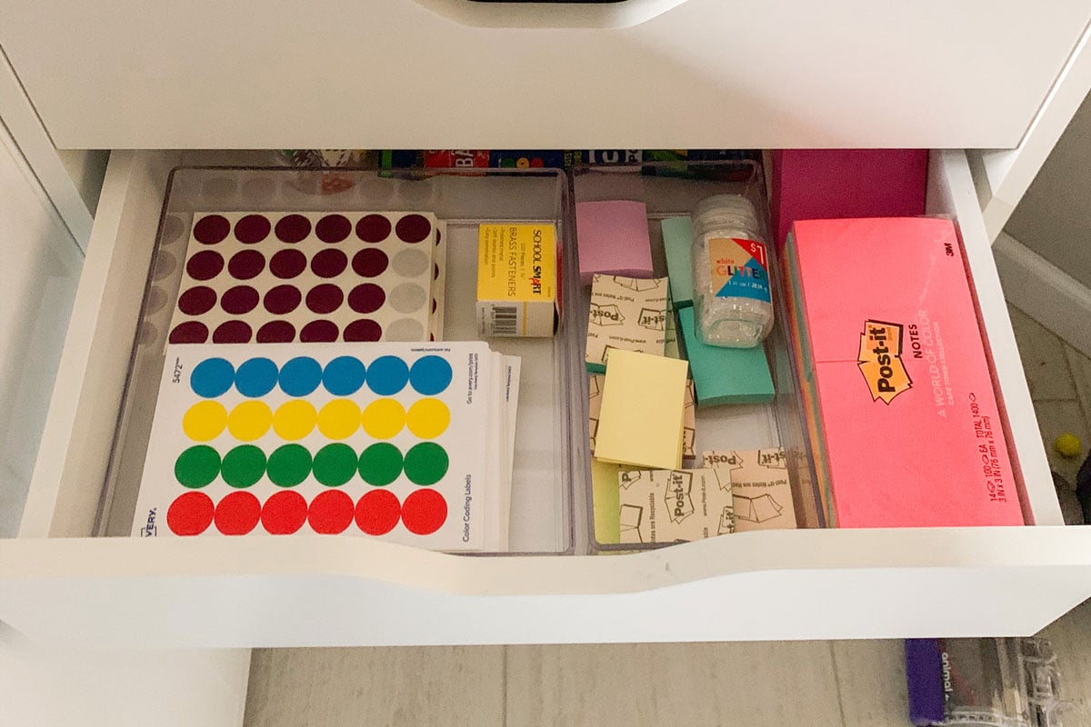 A white drawer is open with dot stickers and sticky notes showing.